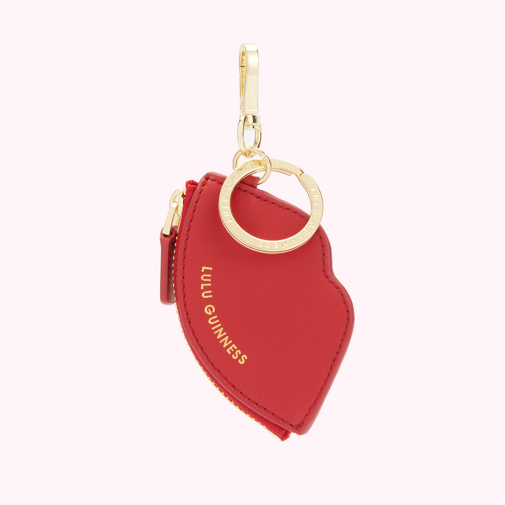 Red Lulu Guinness lip-shaped zip coin purse keychain with gold hardware.
