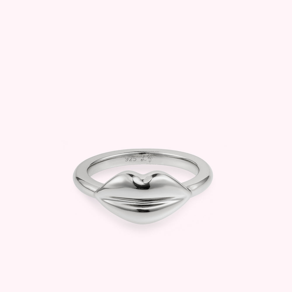 Front image of a silver lip shaped ring on a white background.