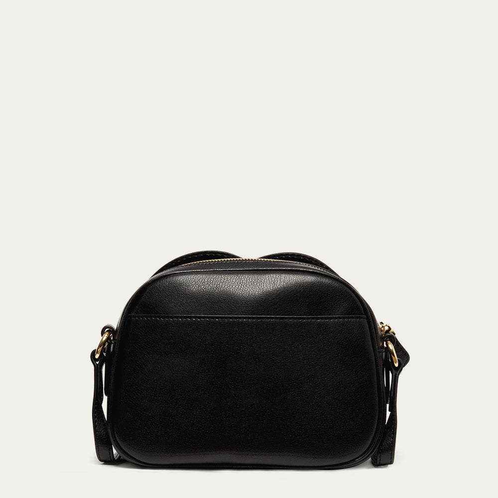 Back image of a black leather crossbody bag on a light gray background revealing the back pocket 