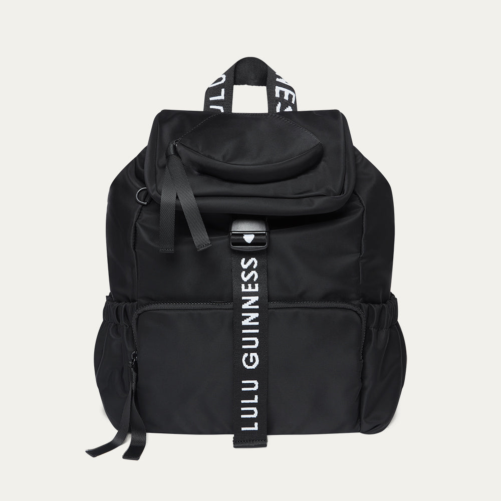 Black backpack with Lulu Guinness strap on a light gray background