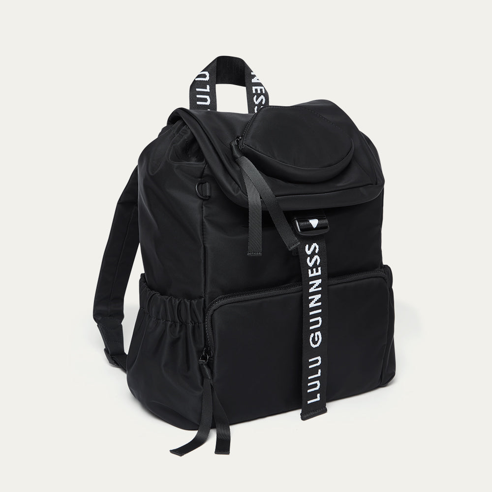 Black backpack with 'Lulu Guinness' branding on a light gray background