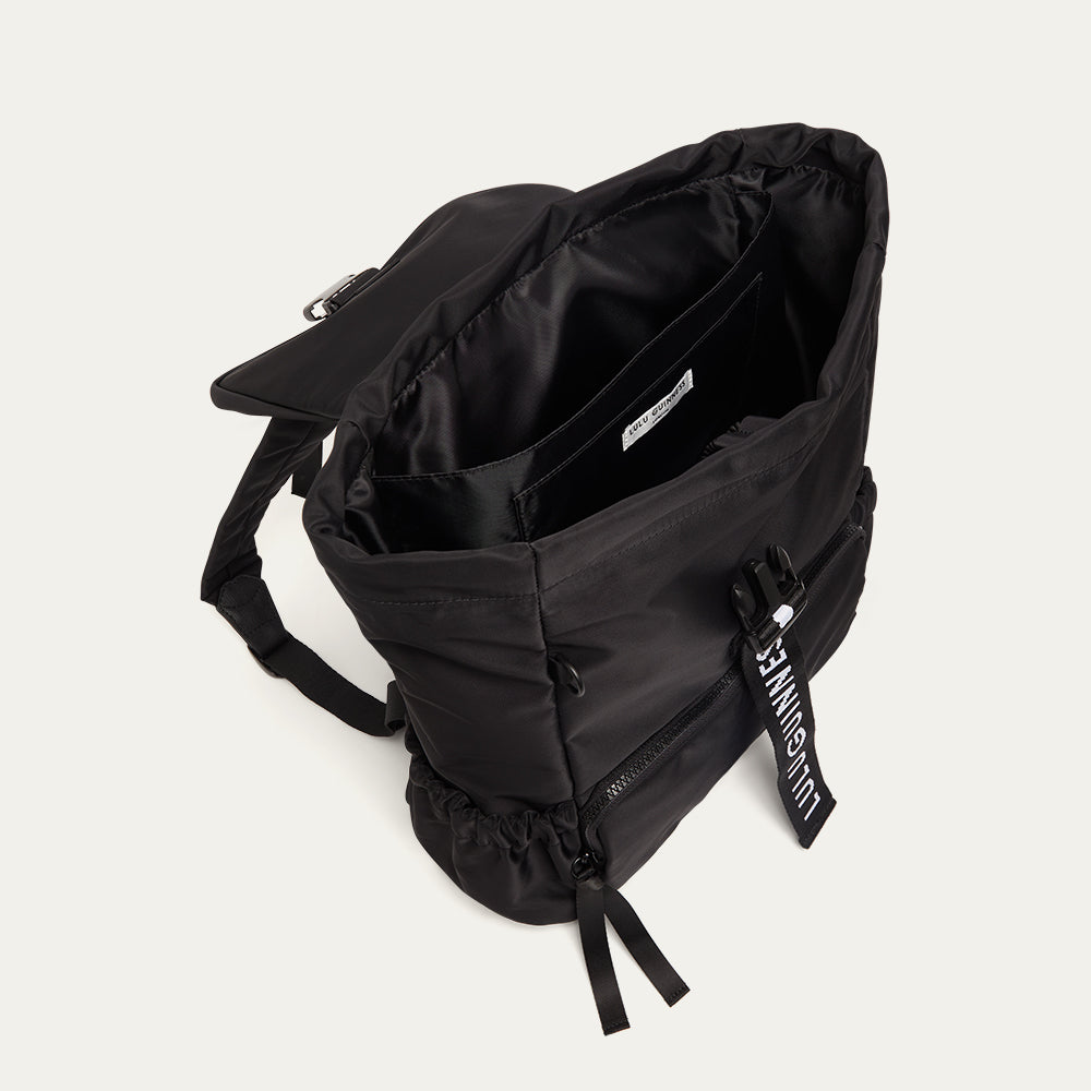 Black backpack open showing a black lining on a light gray background