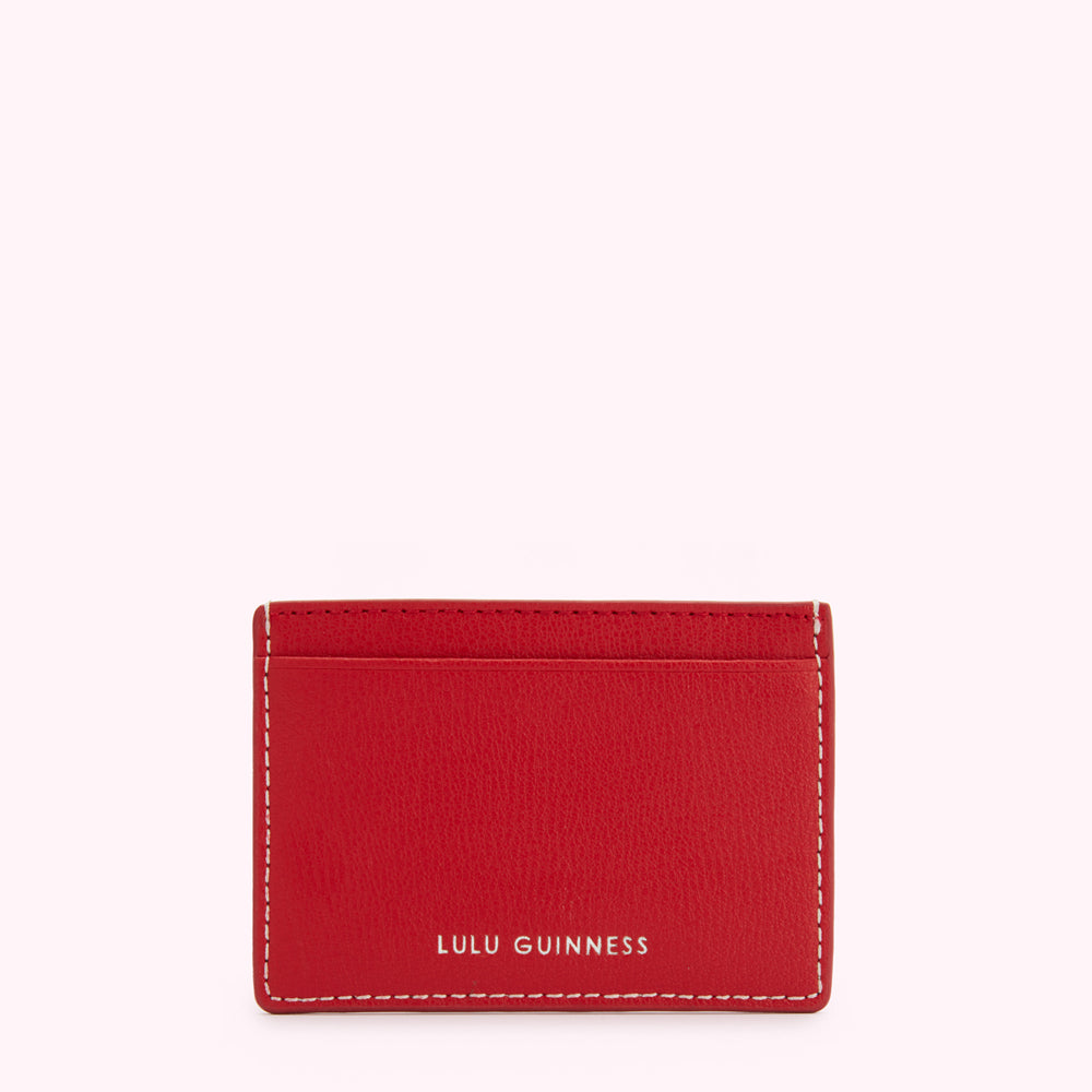 Red leather Lulu Guinness card holder with white stitching.