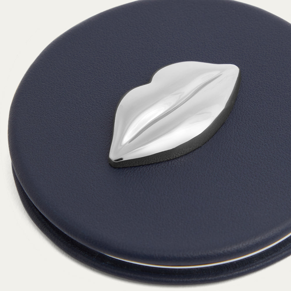 Navy blue compact mirror with a silver lip on top on a white background