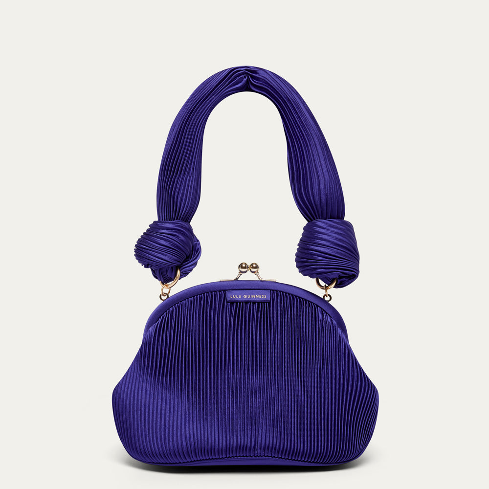 Purple pleated satin handbag with a shoulder handle on a light gray background