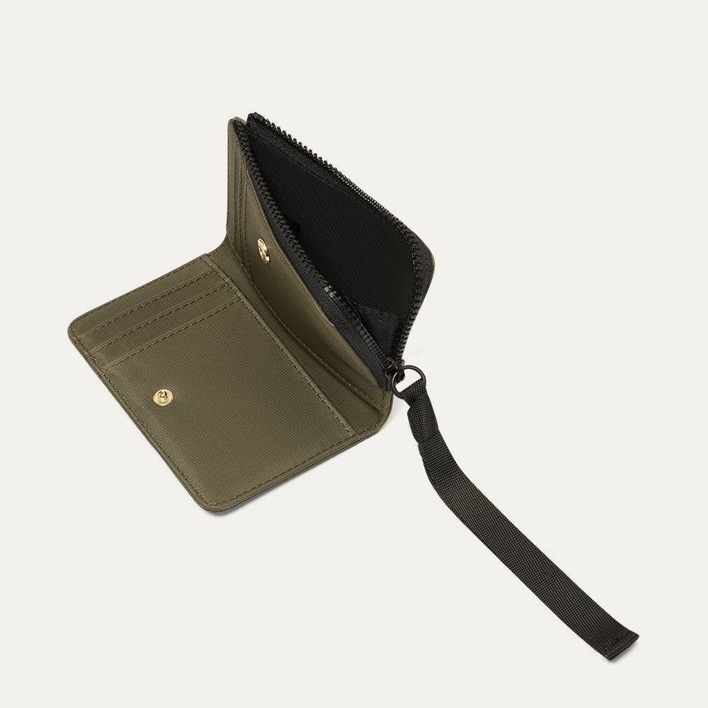 Green wallet with a black ribbon zip pull , open on a light gray background