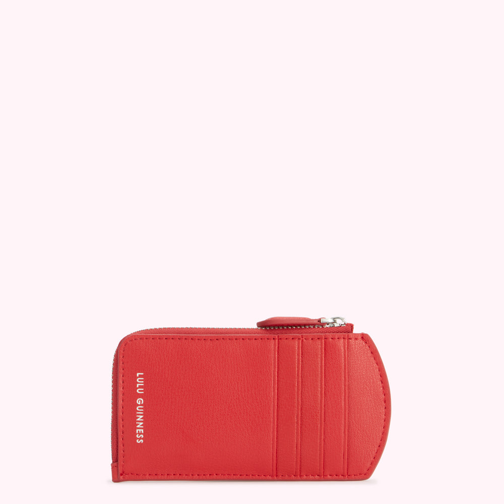 Red Lulu Guinness zip-around coin purse against a white background.
