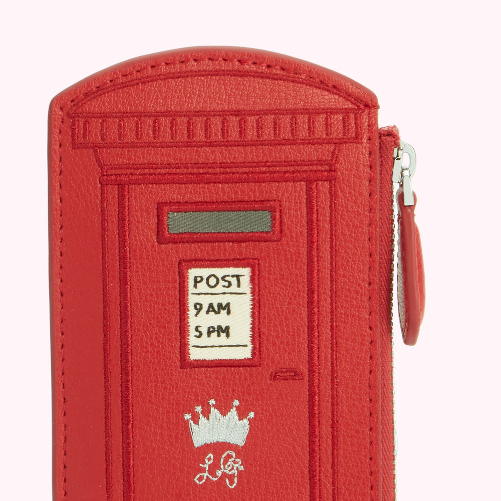 Red leather purse shaped like a British postbox with embroidered details.