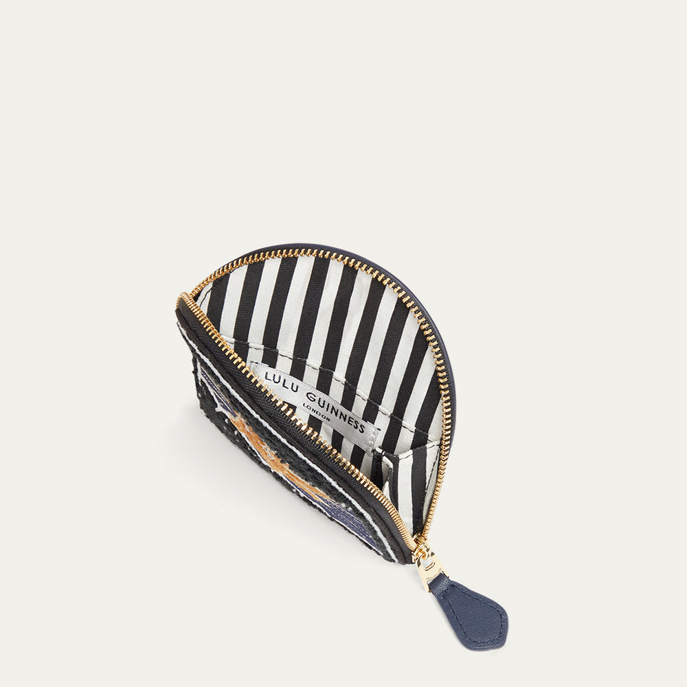 Navy coin purse open to show a black and white striped interior with gold zipper on a white background