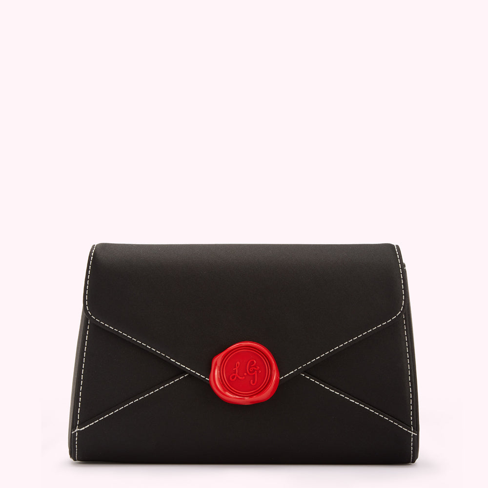 Black envelope-shaped clutch with a red wax seal detail.
