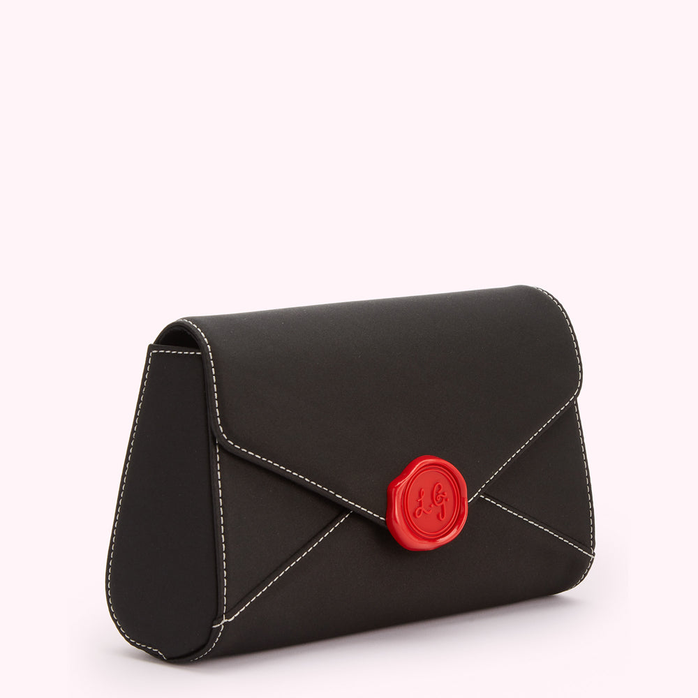 Black envelope-shaped clutch with a red wax seal detail.
