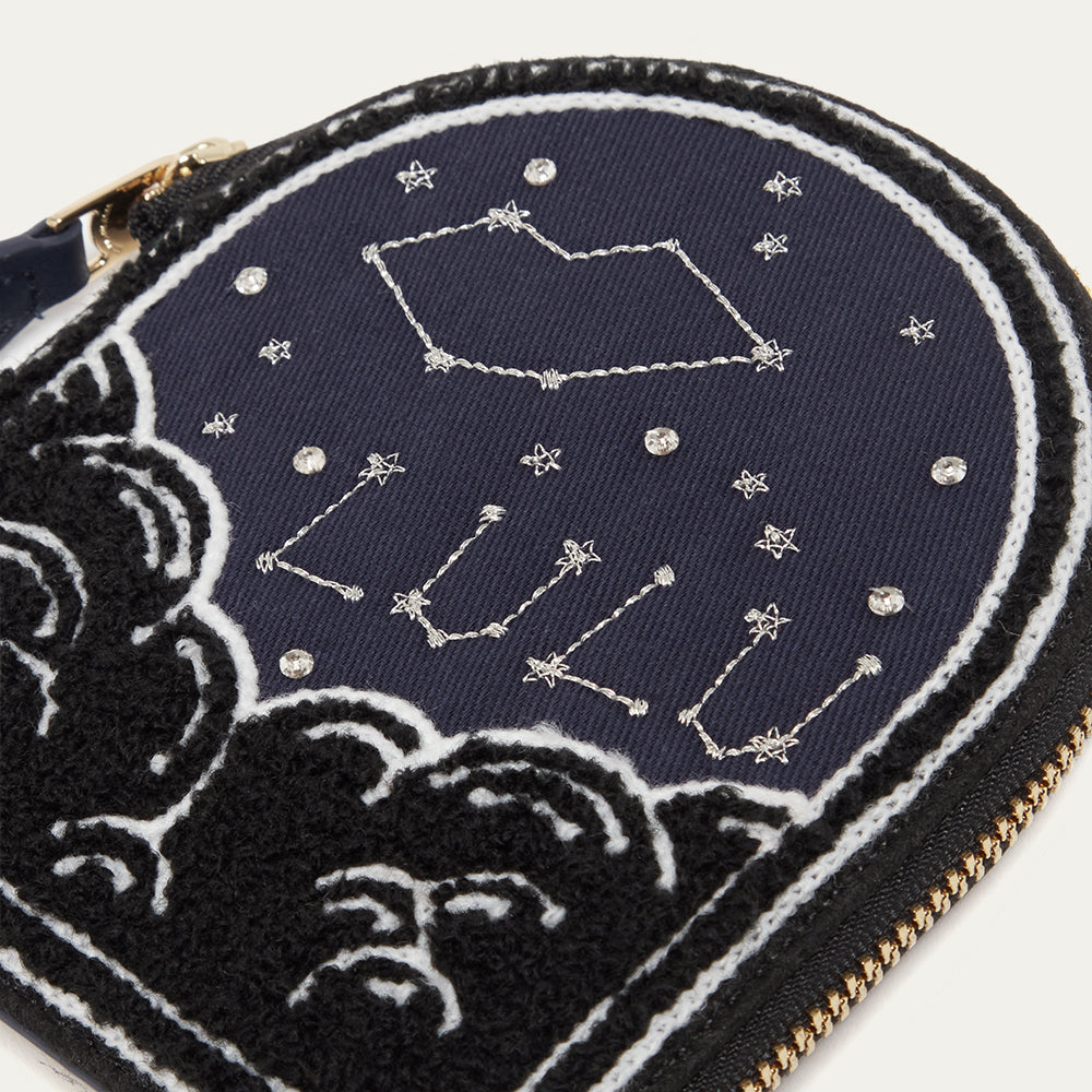 Navy blue coin purse with celestial design and 'Lulu Guinness' branding, featuring stars and constellations.