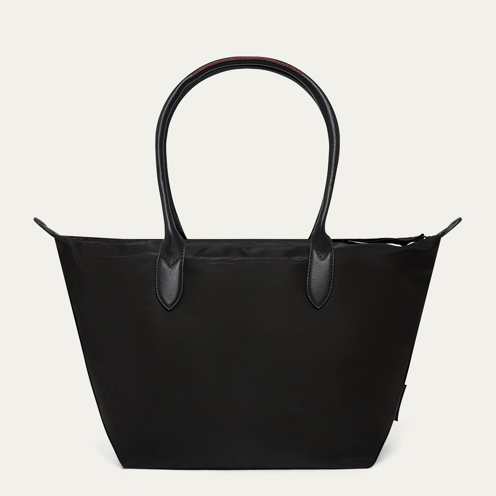 Black tote bag with leather handles on a light gray background