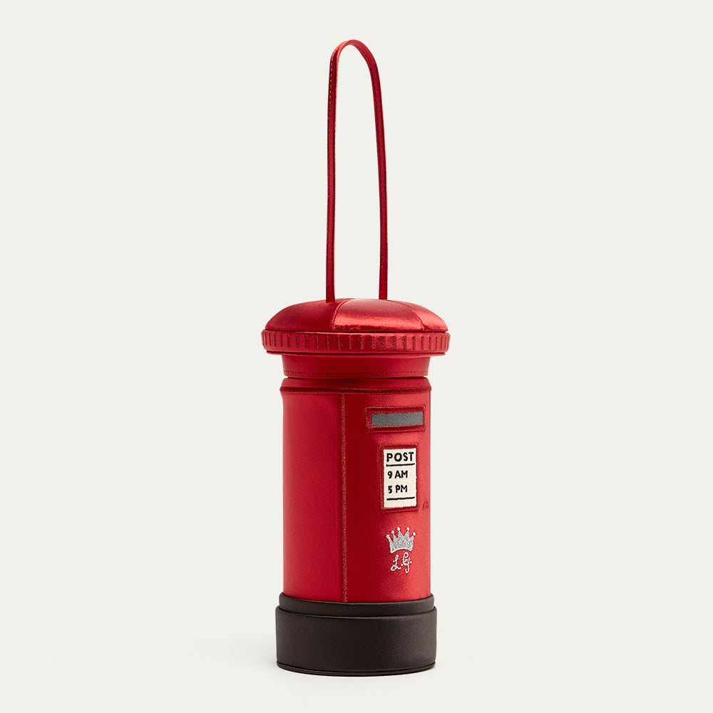 Red satin postbox shaped handbag with a handle on a white background