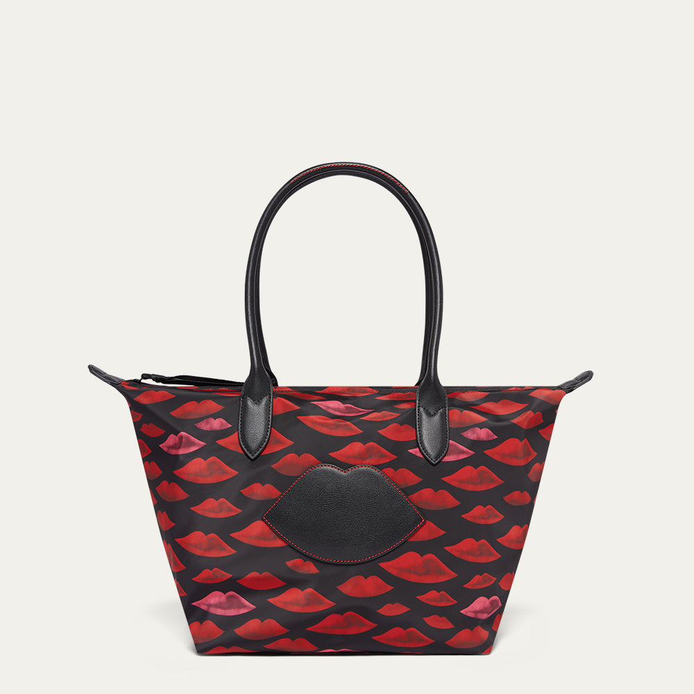 Handbag with red lip pattern and black accents on a light gray background