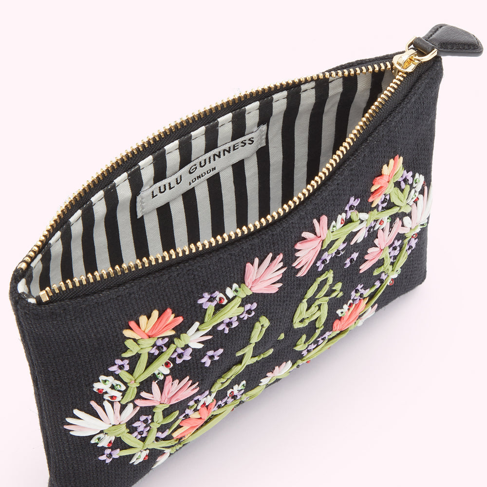 Inside image of a black canvas pouch with pastel floral emobroidered detai land embroidered L.G. monogram.