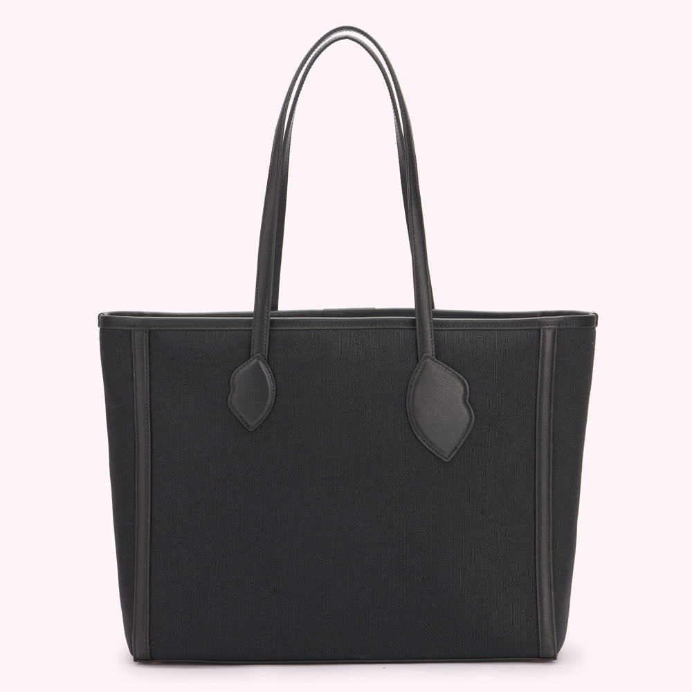 Back images of a large black canvas and leather tote bag with lip handle anchor details.