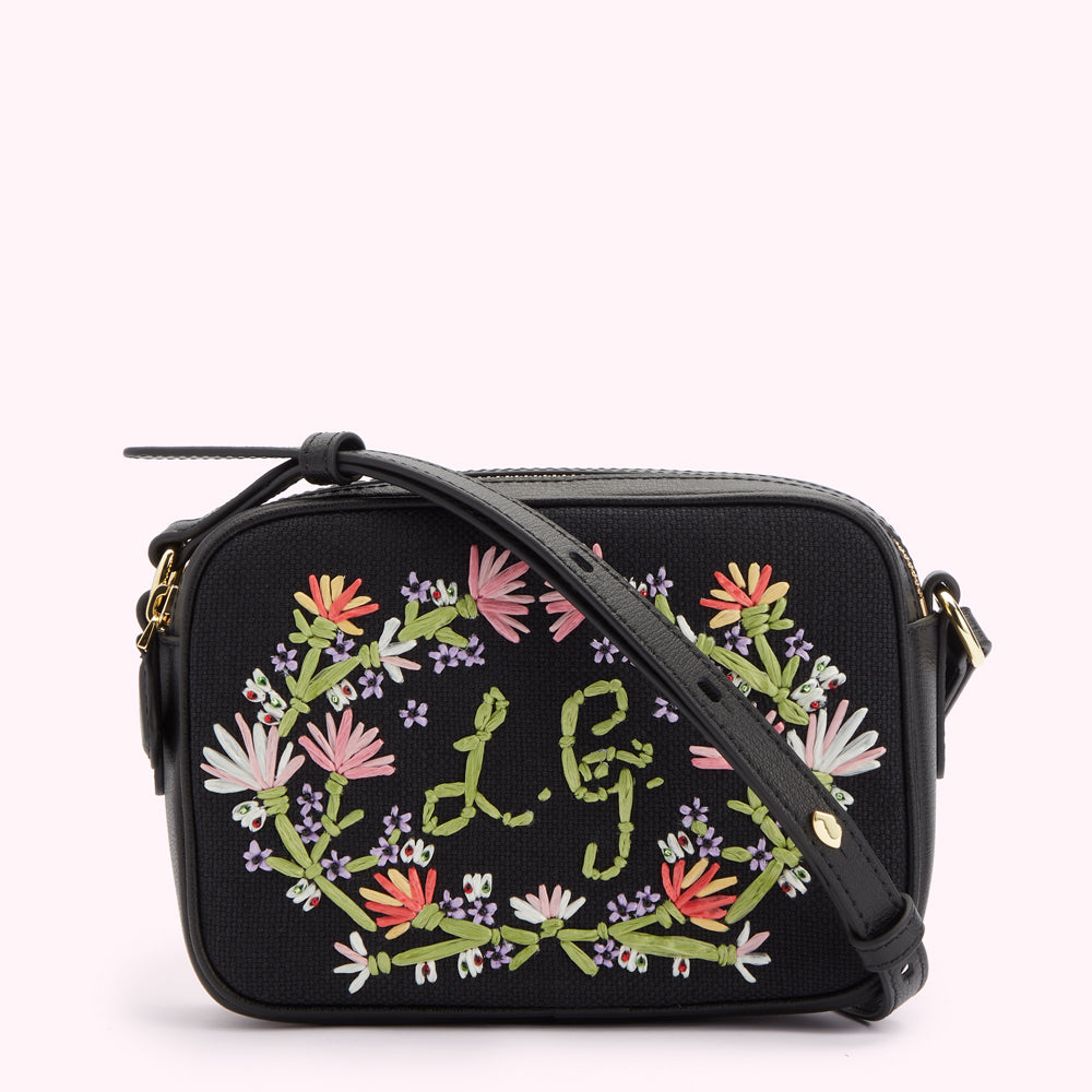 Black canvas and leather handbag with pastel embroidered flowers on the front, L.G monogram at the front center and strap folded across the front.