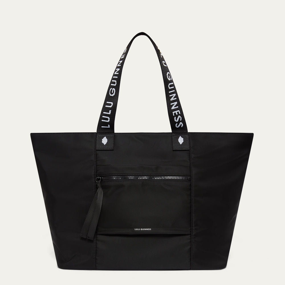 Black tote bag with 'Lulu Guinness' branding on a light gray background