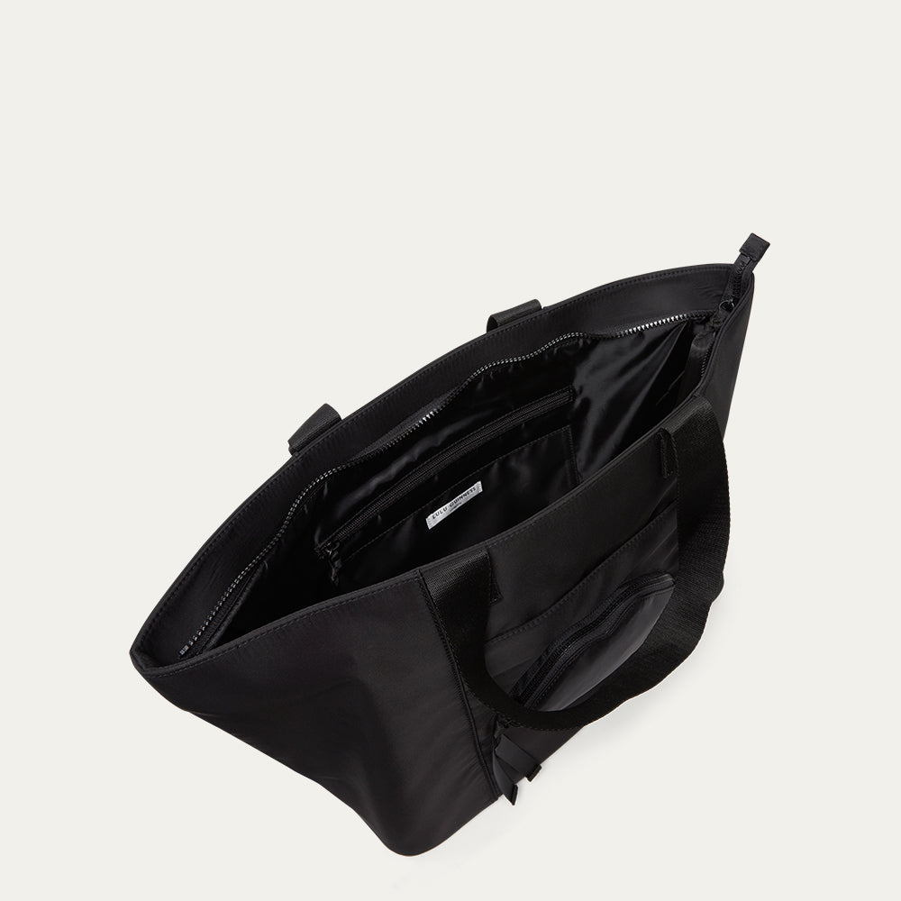Black bag with open front compartment on a light gray background