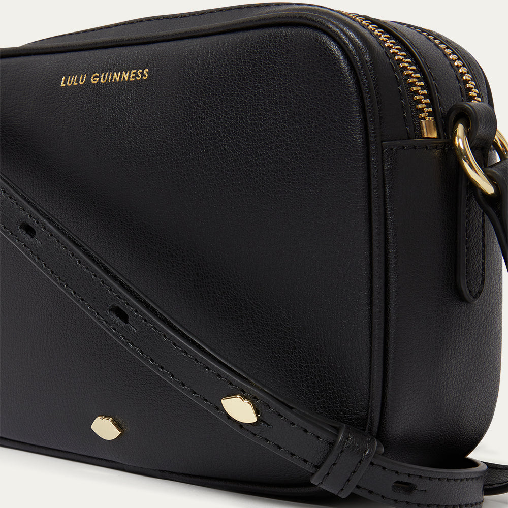 Black handbag with gold accents and 'Lulu Guinness' branding on a white background