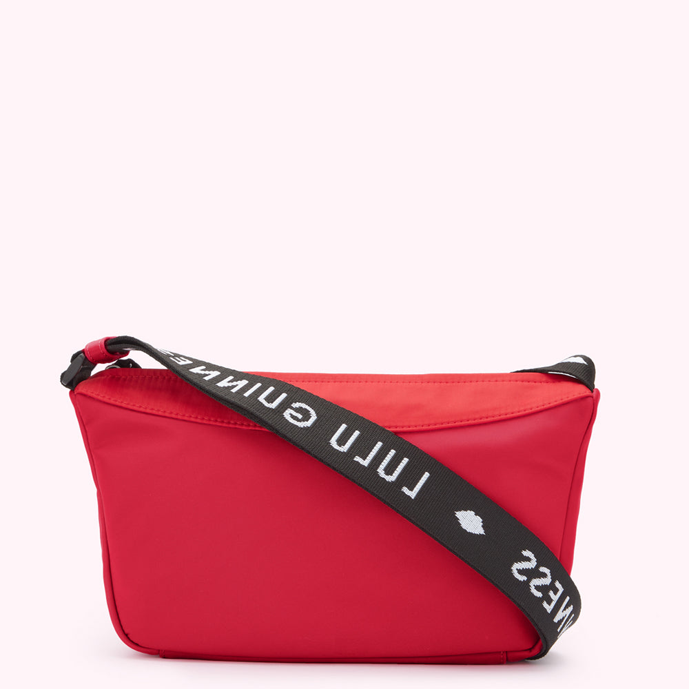 Red and black nylon crossbody bag with "Lulu Guinness" printed on the strap.