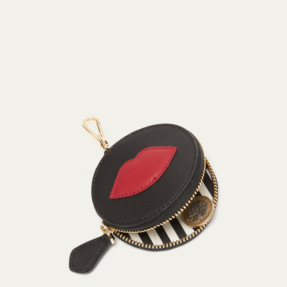 Round black coin purse charm with red lips design on a white background