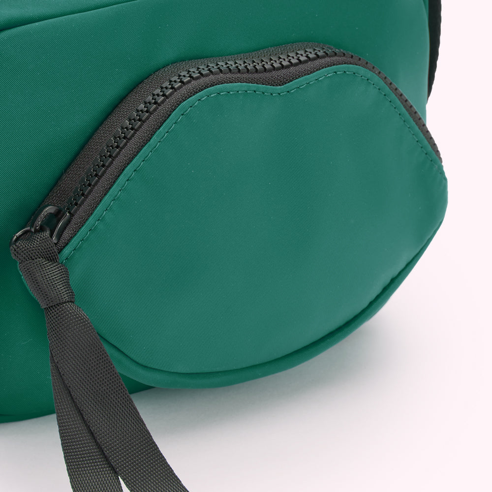 Close-up of a green crossbody bag with a lip-shaped zipper pocket.