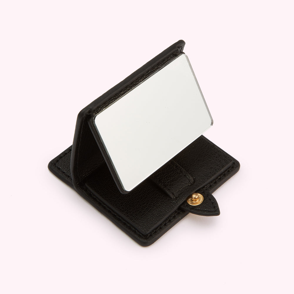 Black leather compact mirror open and standing upright.
