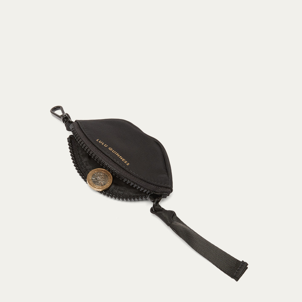 Black pouch with a coin on a light gray background