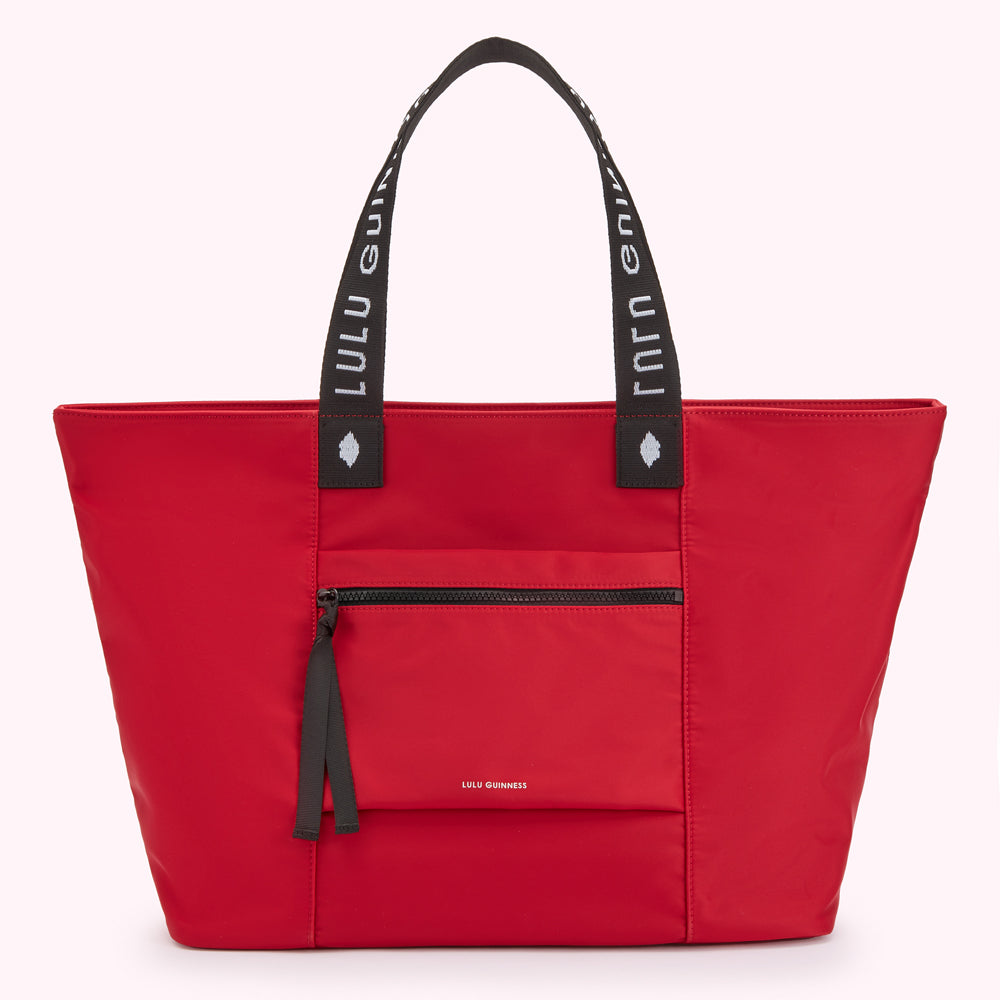 Red Lulu Guinness tote bag with white logo on straps.