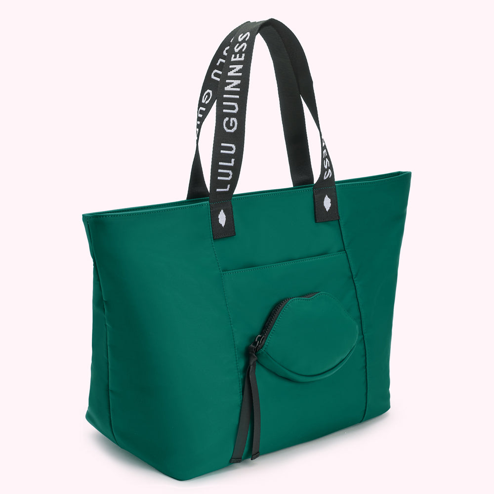 Green tote bag with "Lulu Guinness" on straps and a lip-shaped pocket.