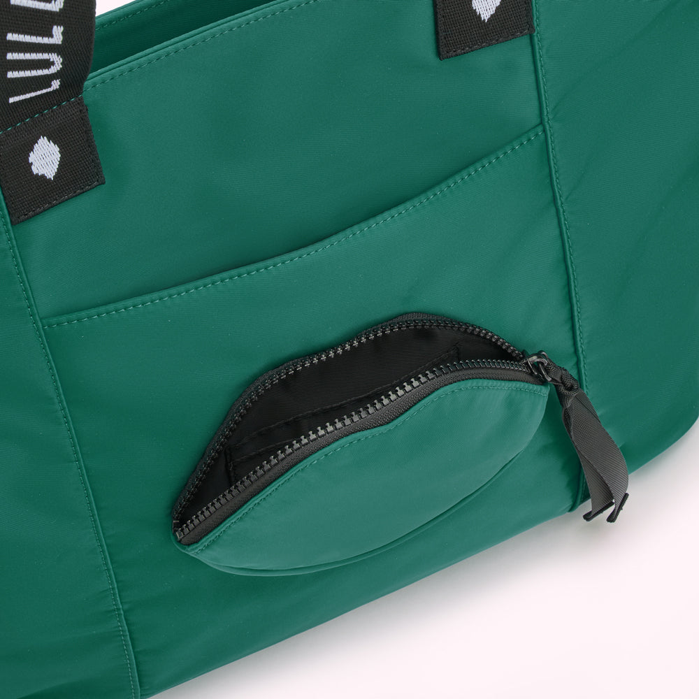 Close-up of a green bag with a lip-shaped zippered pocket.