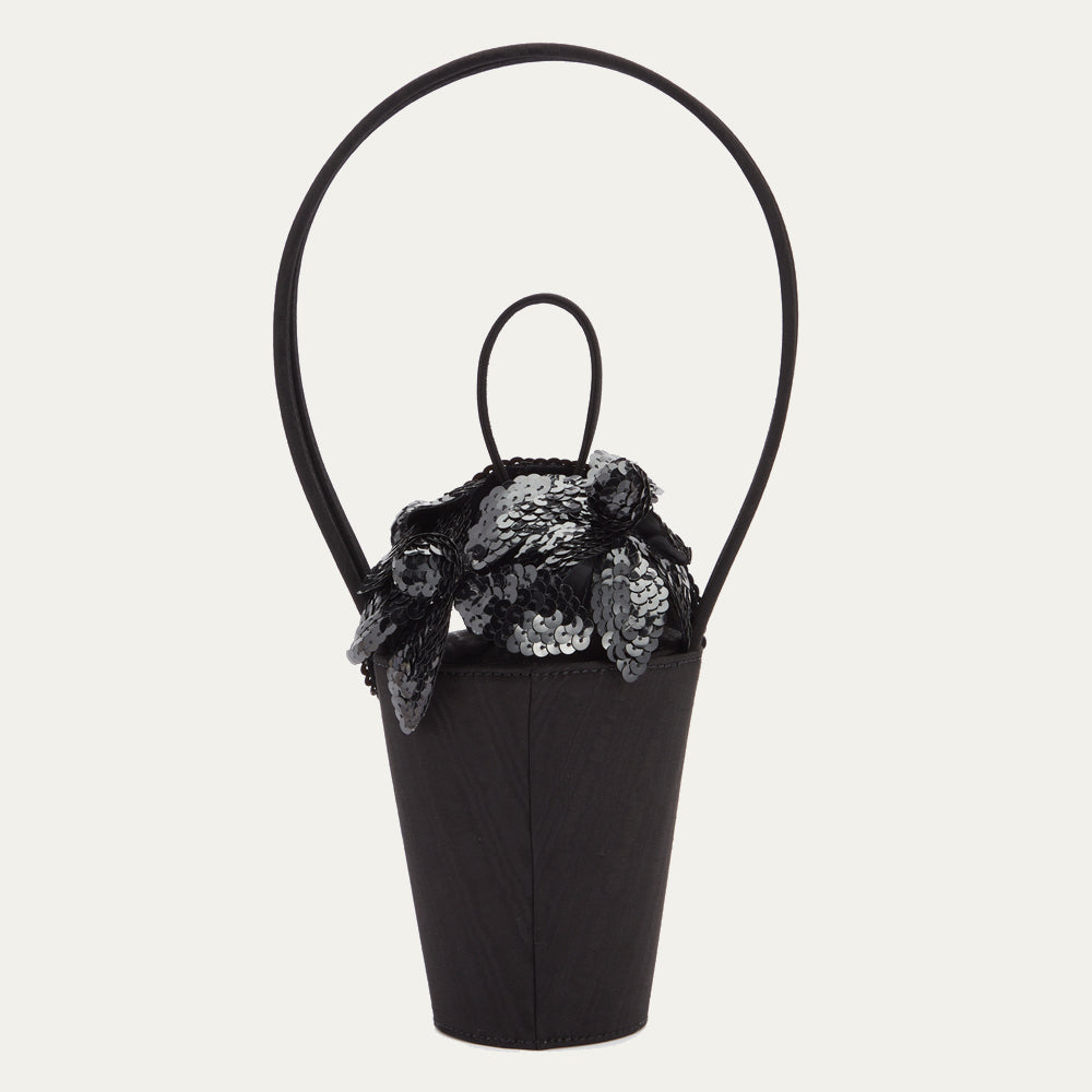 Black satin moire bucket bag with top looped handle and black sequin flowers on the lid.