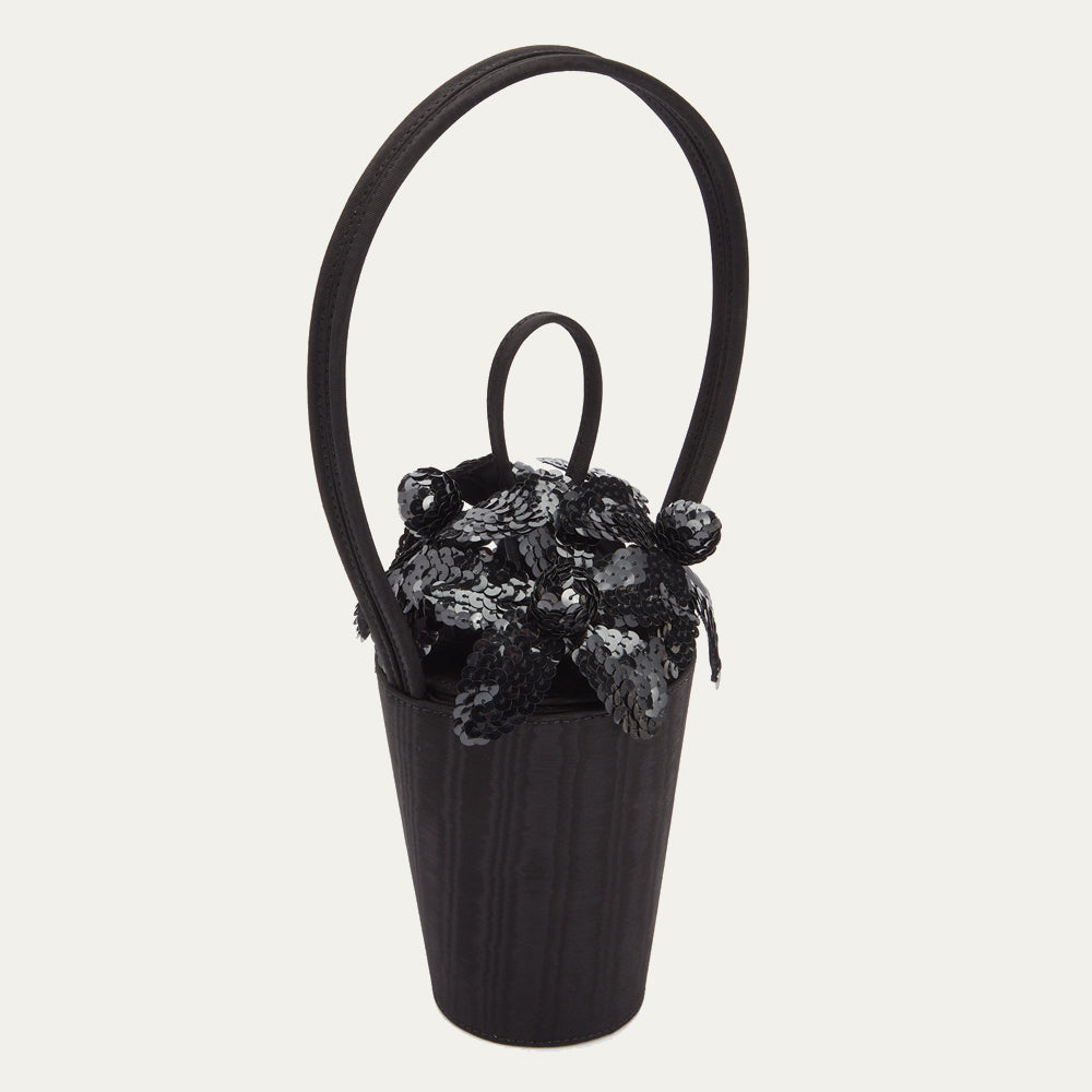 Black satin moire bucket bag with top looped handle and black sequin flowers on the lid.