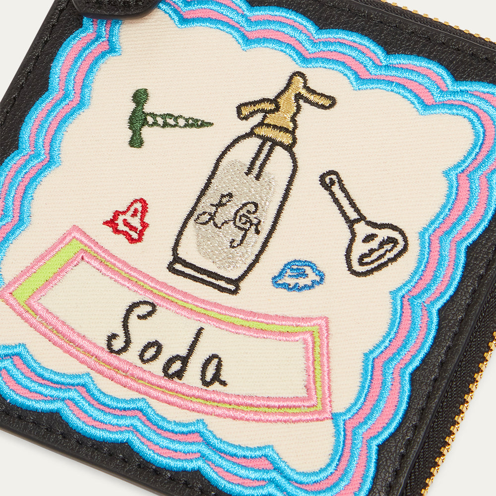 Embroidered coin purse with a bottle labeled 'Soda' and various icons on a colorful border.