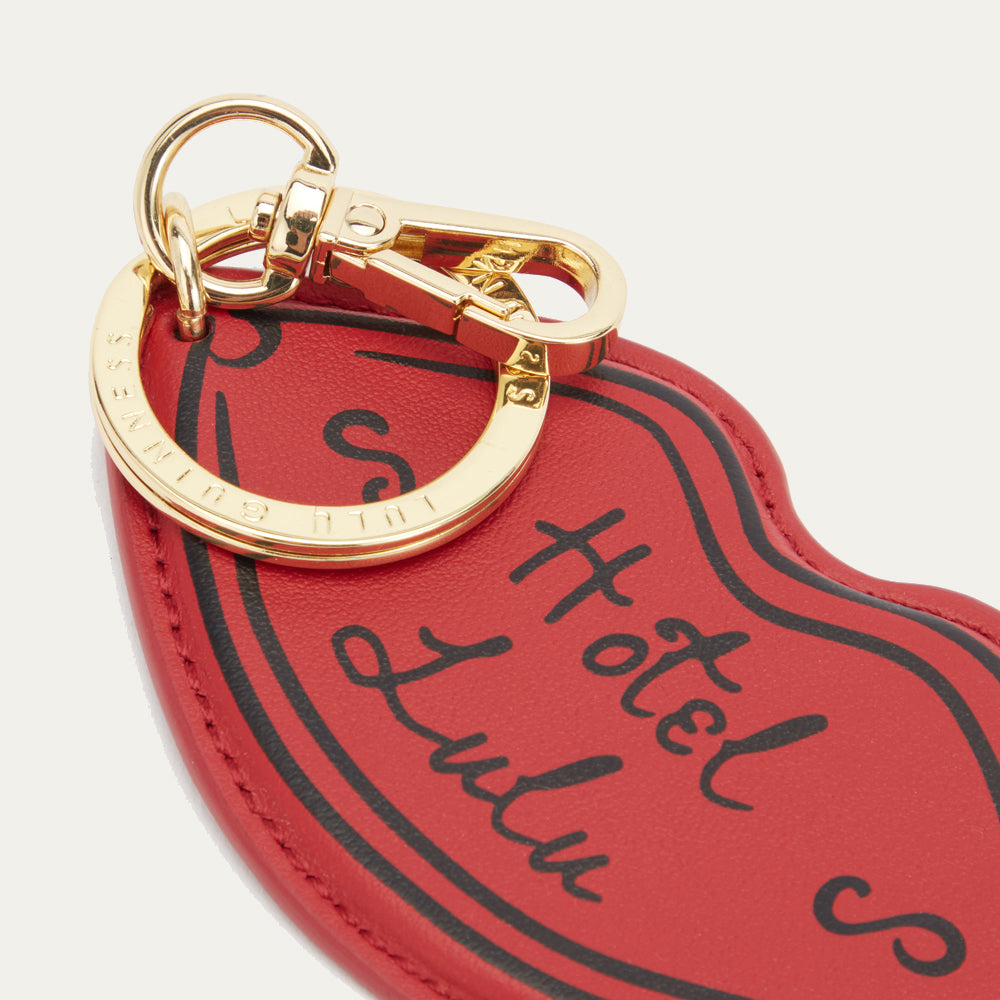 Red keychain with gold ring and 'Hotel Lulu' text on a white background