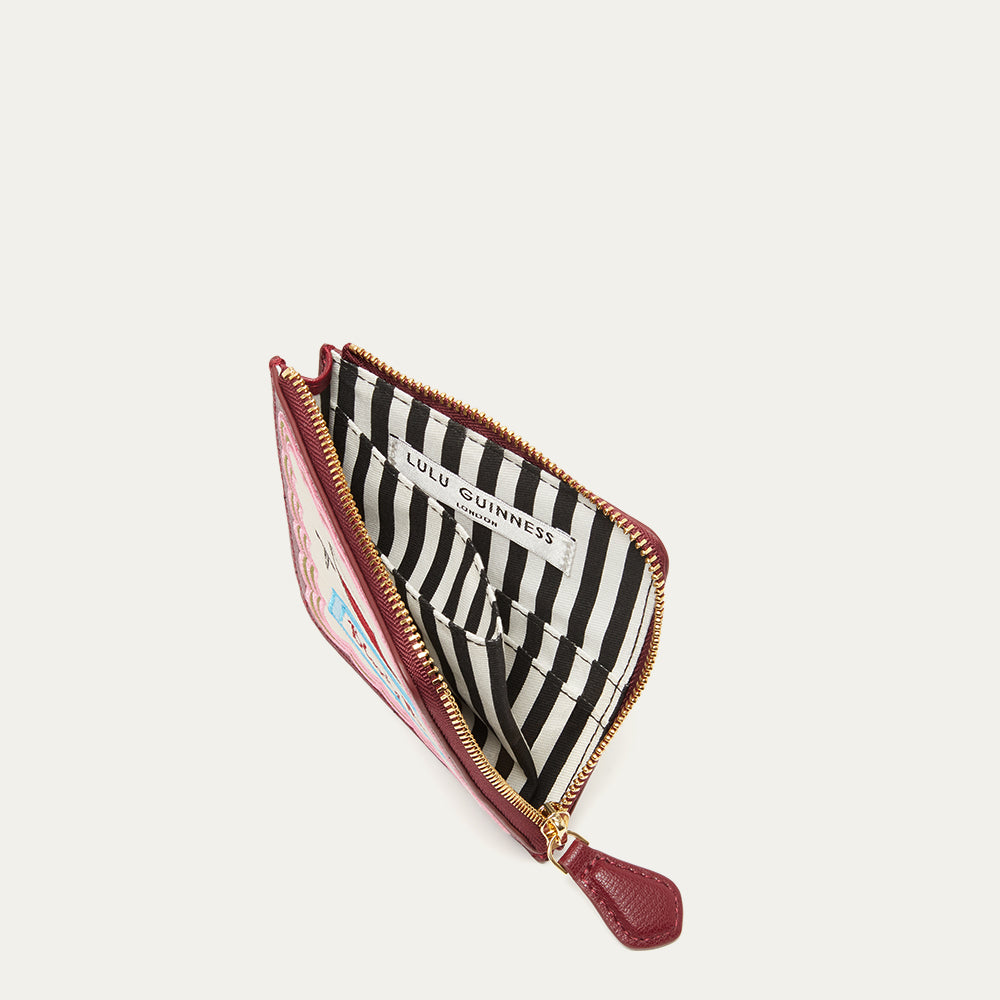 Inside of a coin purse revealing a striped lining with visible brand name on a white background