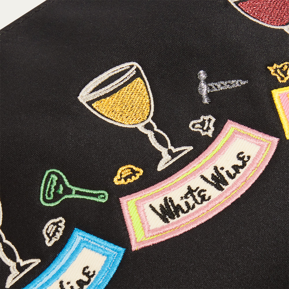Black satin pouch with colorful embroidered wine-themed designs on a black background