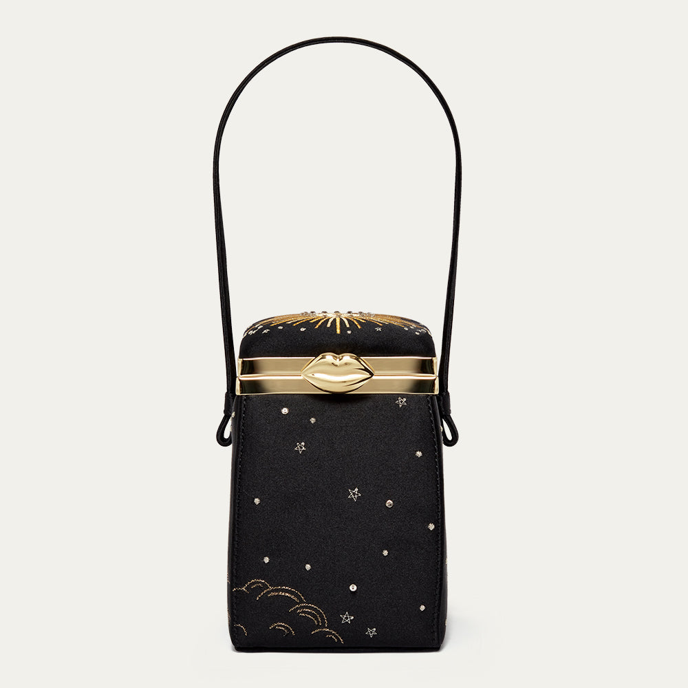 Black satin handbag with gold accents and star designs on a light gray background