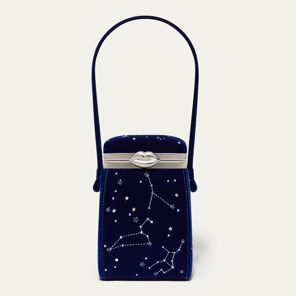 Navy blue velvet handbag with star constellation design on a light gray background