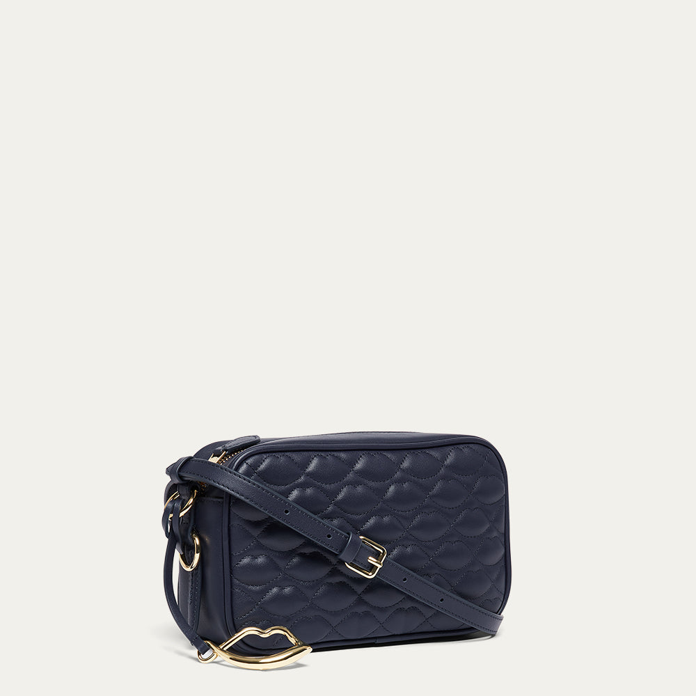 Navy leather quilted handbag with gold accents on a light beige background