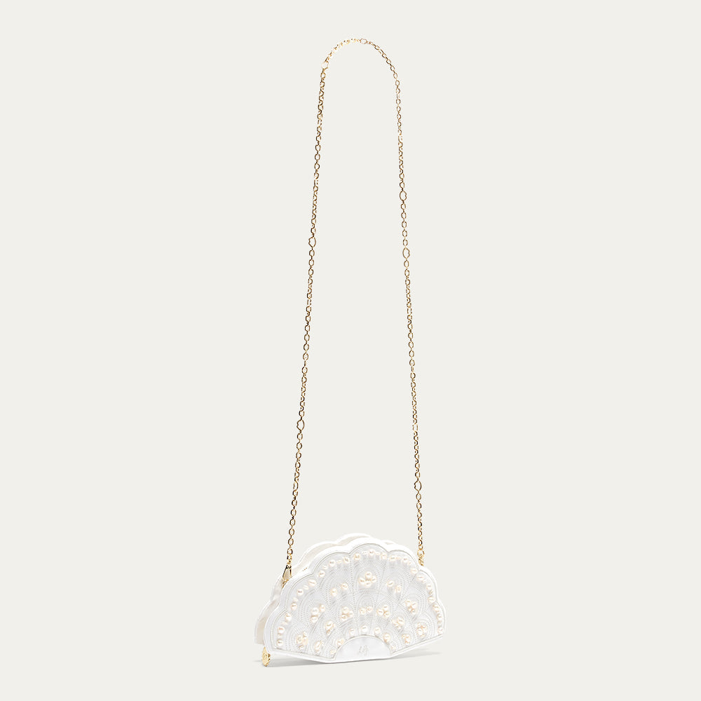A white satin fan-shaped handbag with a gold chain on a light beige background