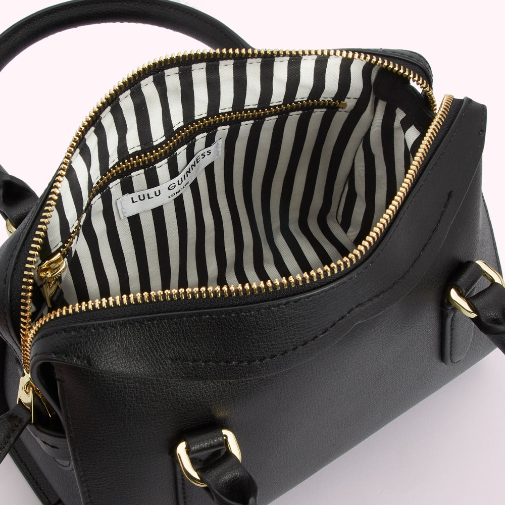 Open black Lulu Guinness handbag with black and white striped interior.