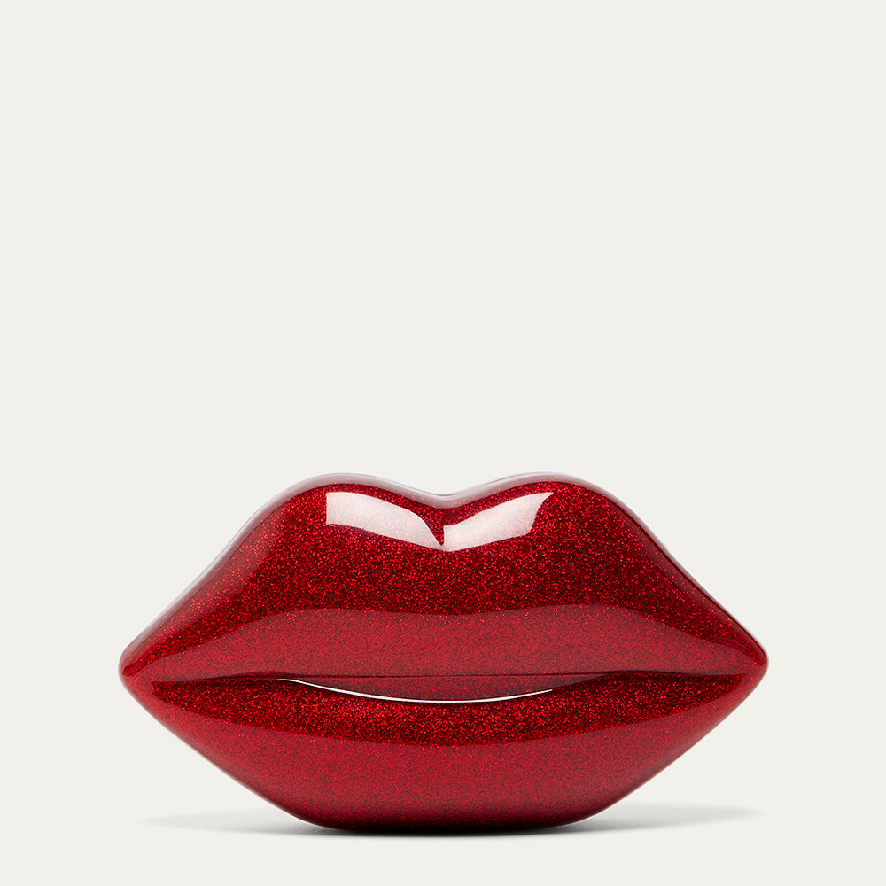 Red glittery lips-shaped clutch on a light grey background