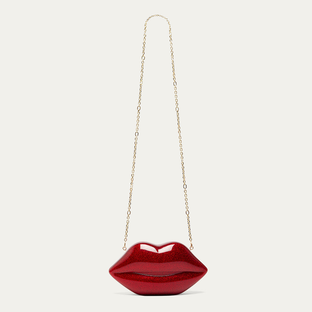 Red lip-shaped handbag with a gold chain on a light gray background
