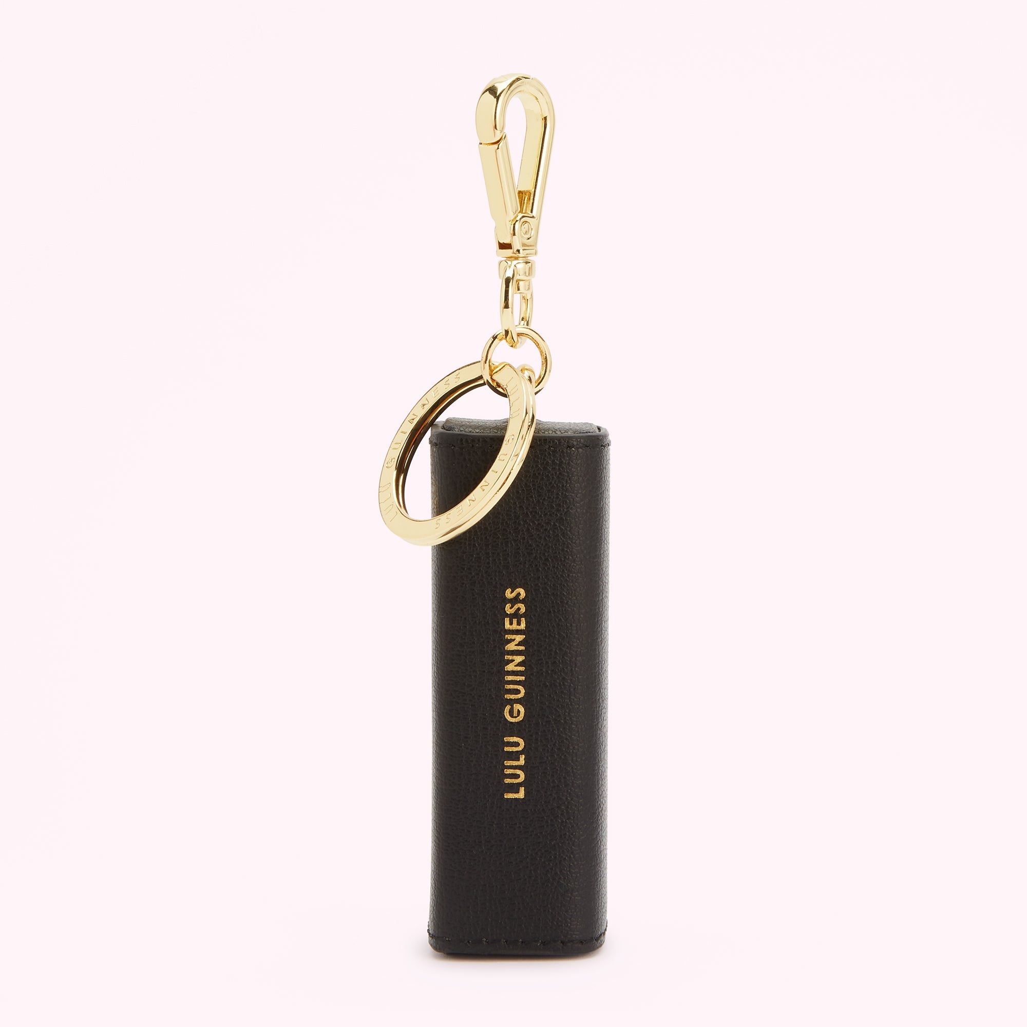 Black Lulu Guinness keyring with gold-tone hardware against a white background.
