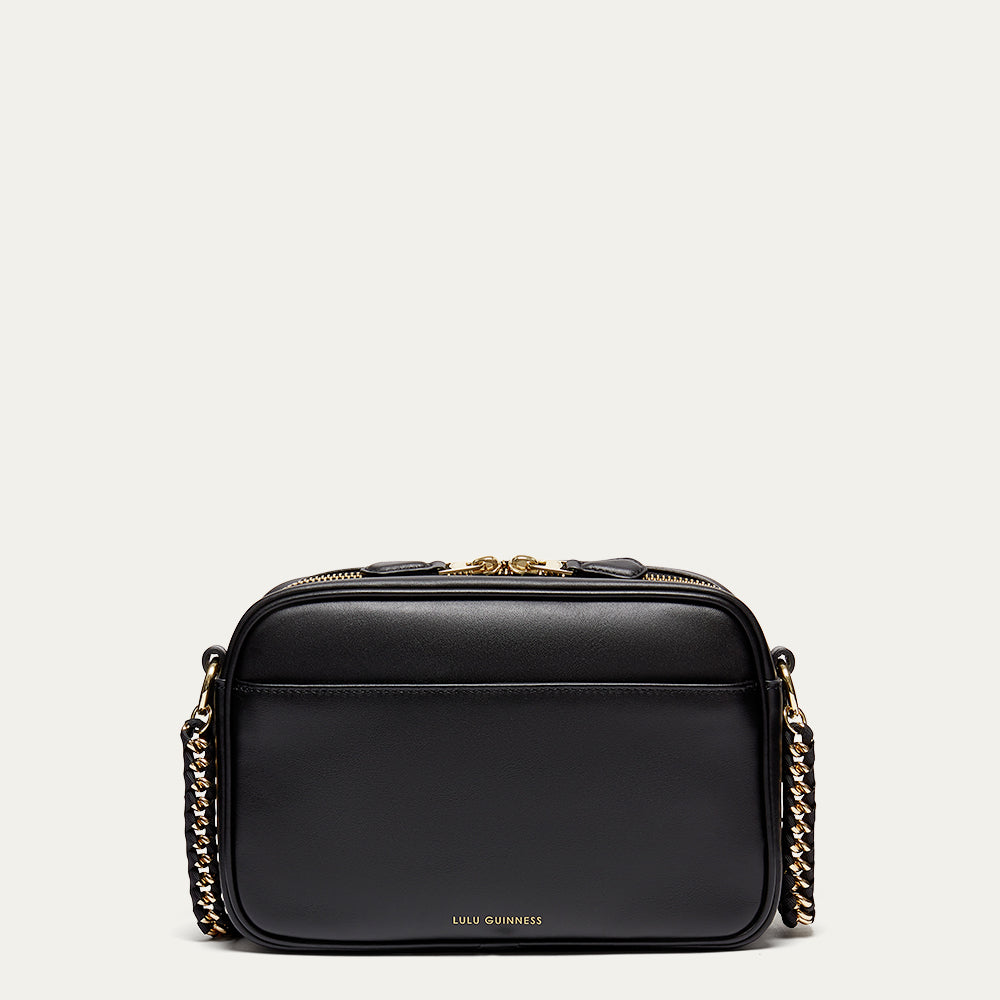 Black handbag with gold chain detail on a light gray background