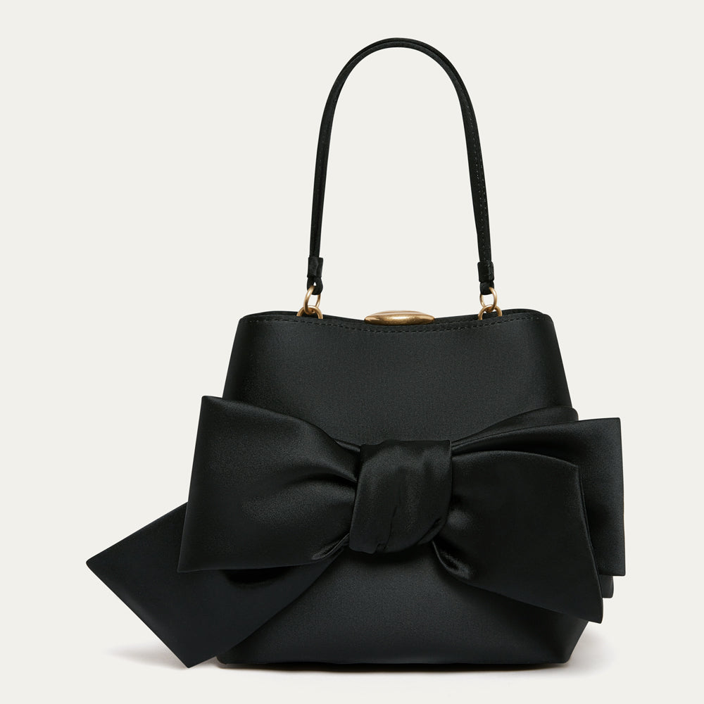 Black satin handbag with a bow on the front on a white background.