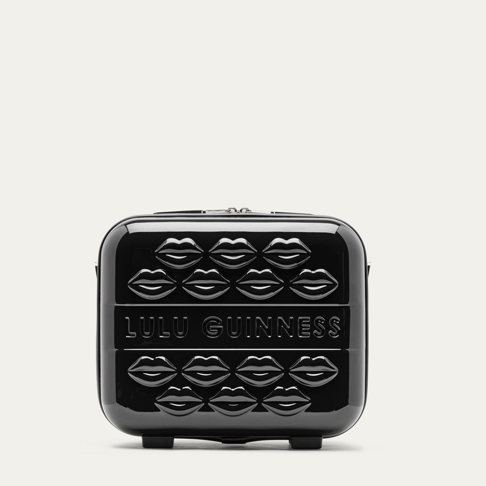 Black vanity case with embossed lips and 'Lulu Guinness' branding on a light gray background